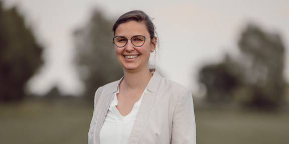 Kerrin Langer vor unscharfem Hintergrund, wie sie in die Kamera lacht.